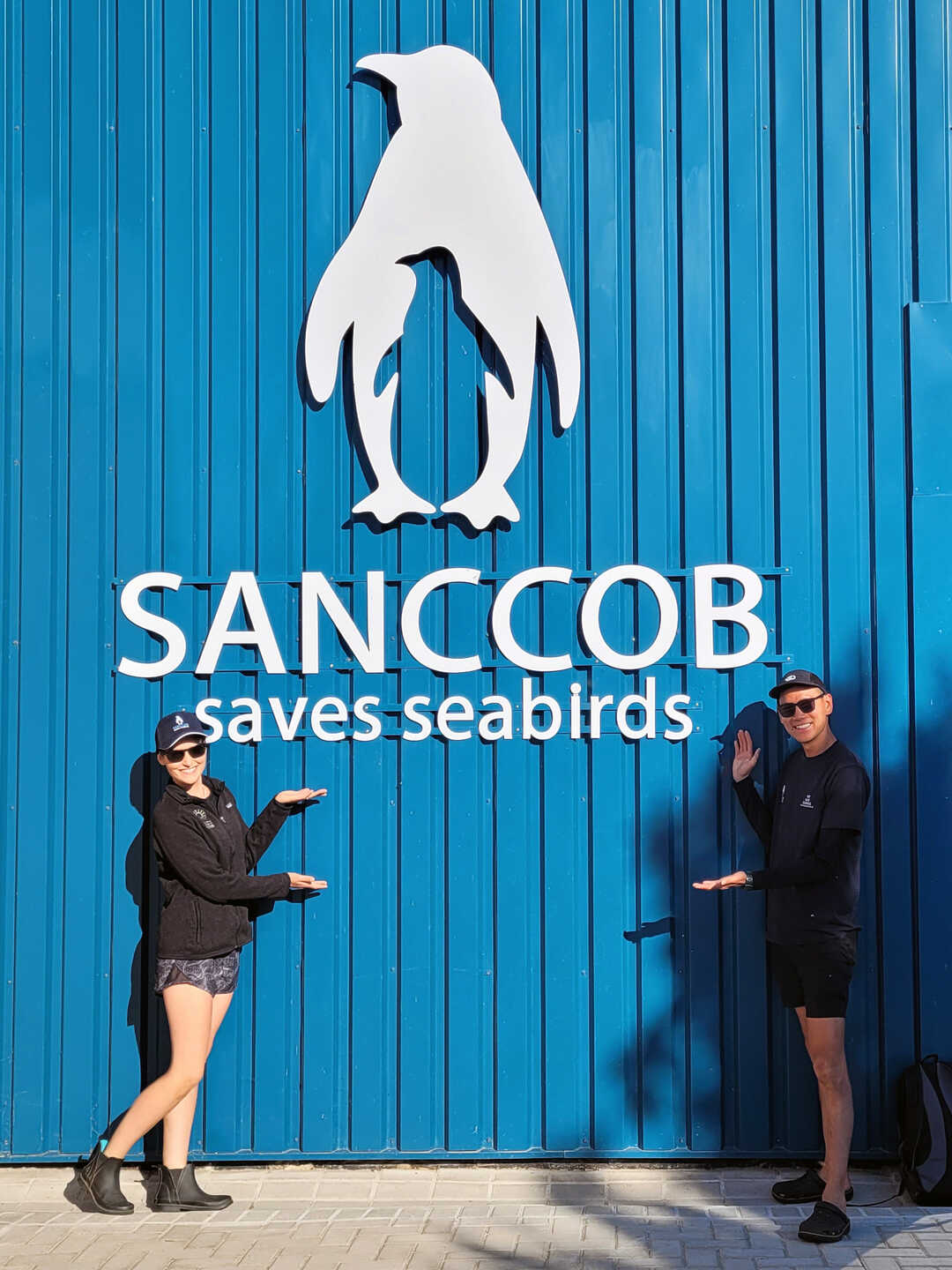 Academy Biologists Kelsey Paulling and Tim Wong pose in front of the SANCCOB facility in Cape Town, South Africa