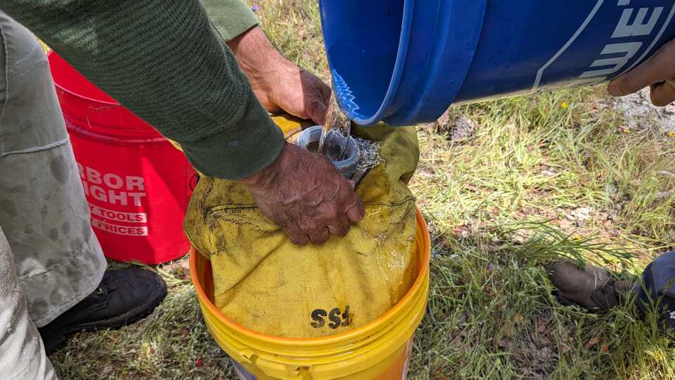 A participant fills up a yellow bladder full of water, to be used to contain fires. 