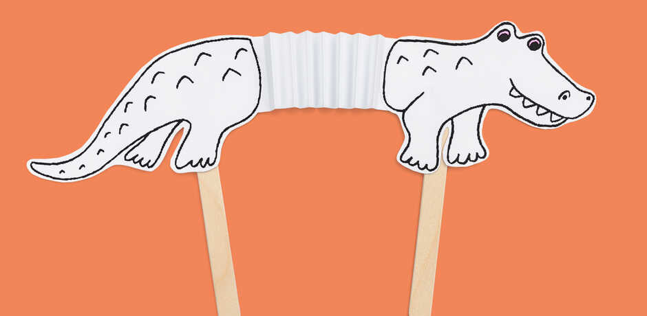 Paper alligator accordion craft against orange background
