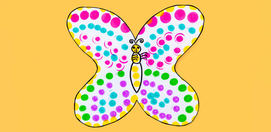 Handmade paper butterfly craft against yellow background