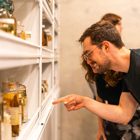 NightLife Plus guest points in amazement at a scientific specimen behind the scenes at Cal Academy