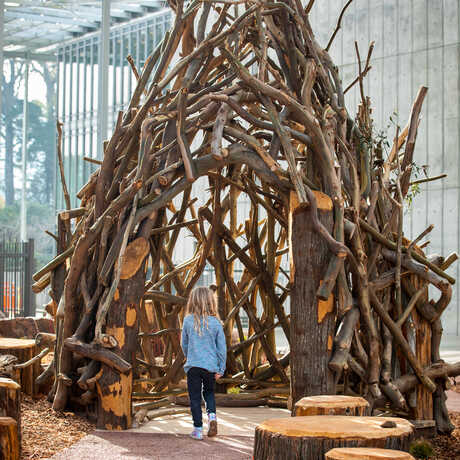 Young girl enters the Nest structure in Wander Woods